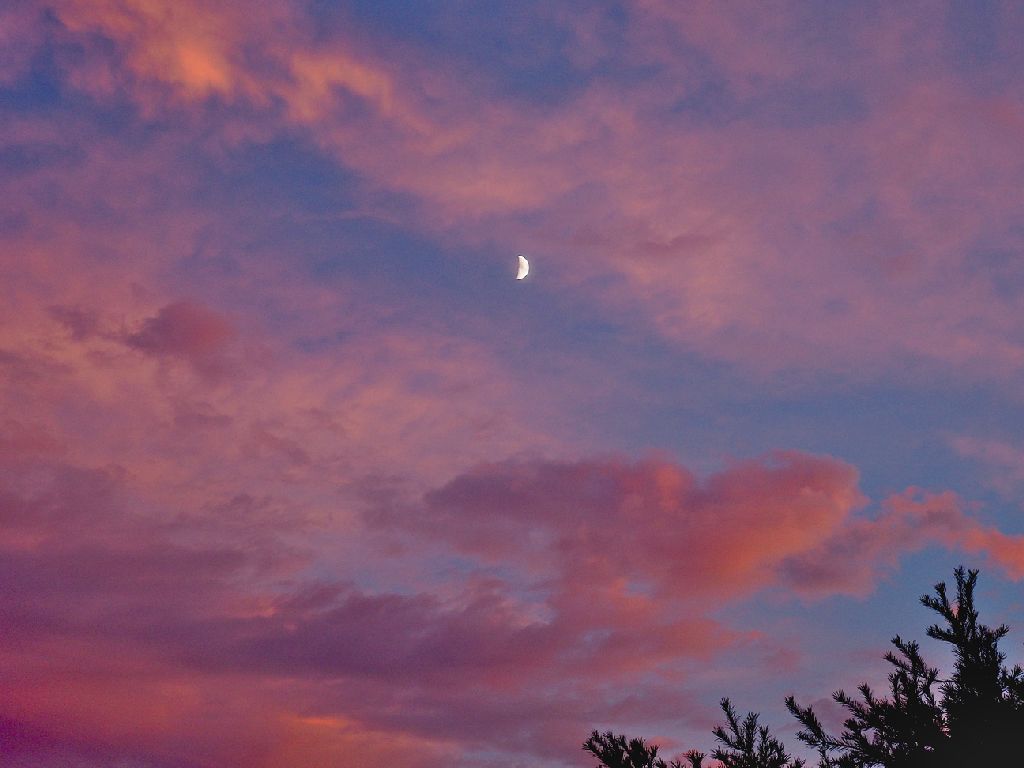 trăng khuyết giữa trời hoàng hôn đầy mây