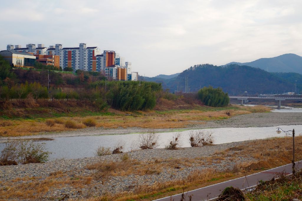 paysage fluvial avec des collines et quelques immeubles